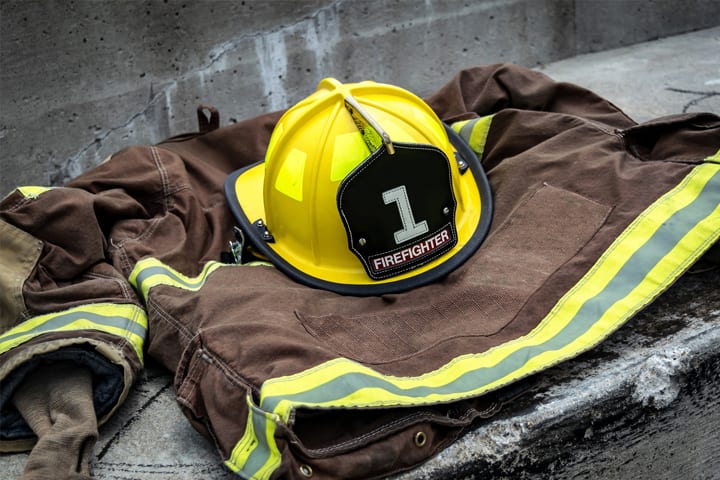 A Firefighter hat and coat lay on the ground