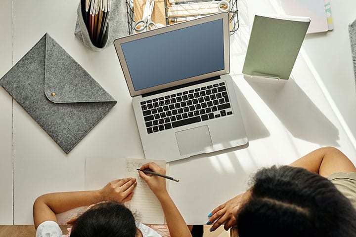 A mother and daughter work at a computer