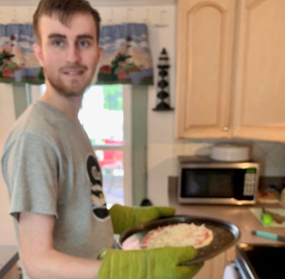 CMCSSSD student, Ian Thomas, proudly displays the pizza he made from a kit distributed to students by the school to give them a family activity to participate in that helped them with communication and life skills.