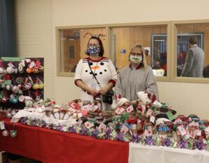 Staff members smile behind a table of goodies made by students at Burlington County Special Services School District for their annual craft fair.